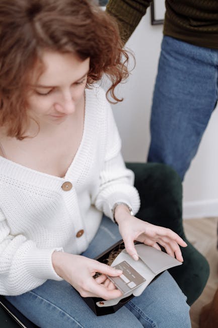 A woman sits indoors reviewing her credit card statement, capturing a moment of financial management.
