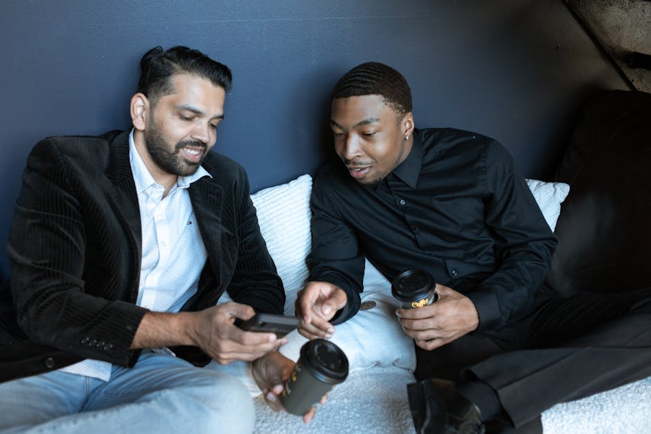 Two men enjoying coffee during a relaxed business meeting indoors.